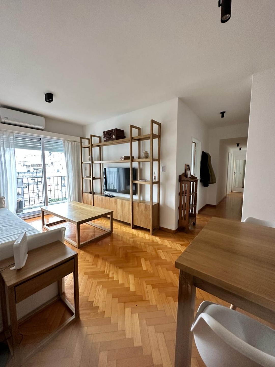 Living and dining area with a corridor and balcony door