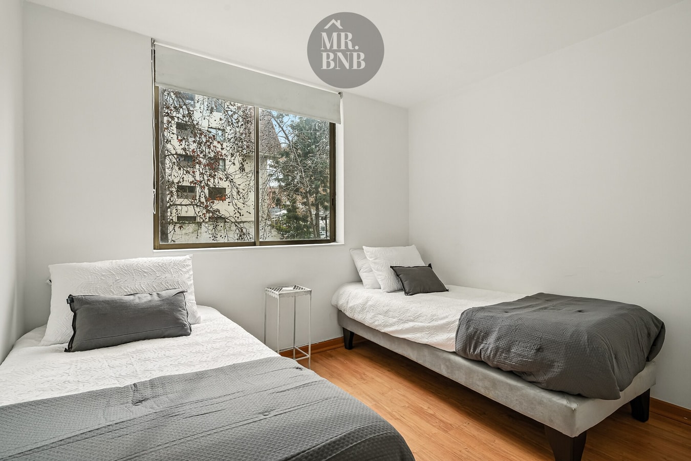Dormitorio con dos camas individuales junto a la ventana