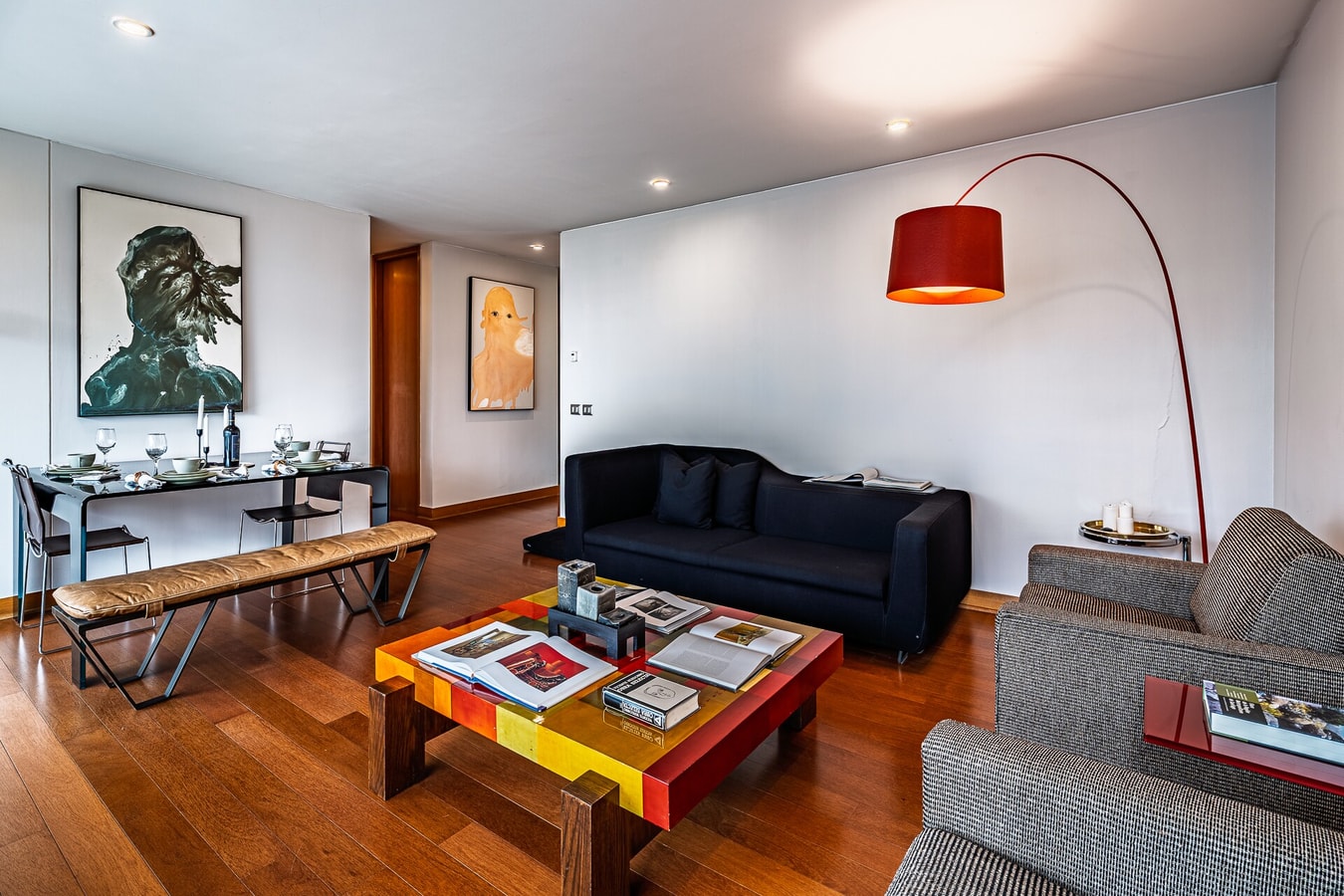 Living comedor con sofás, mesa de centro y lámpara de piso sobre piso de madera.