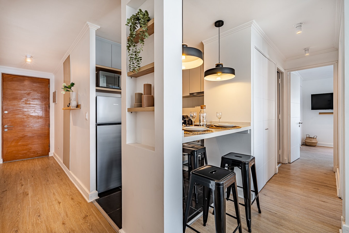Entrada con barra de cocina, banquetas y puerta de acceso