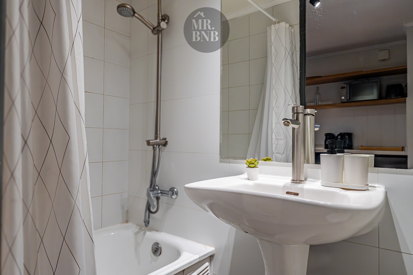 Baño con ducha, tina, lavamanos pedestal y repisas con amenities