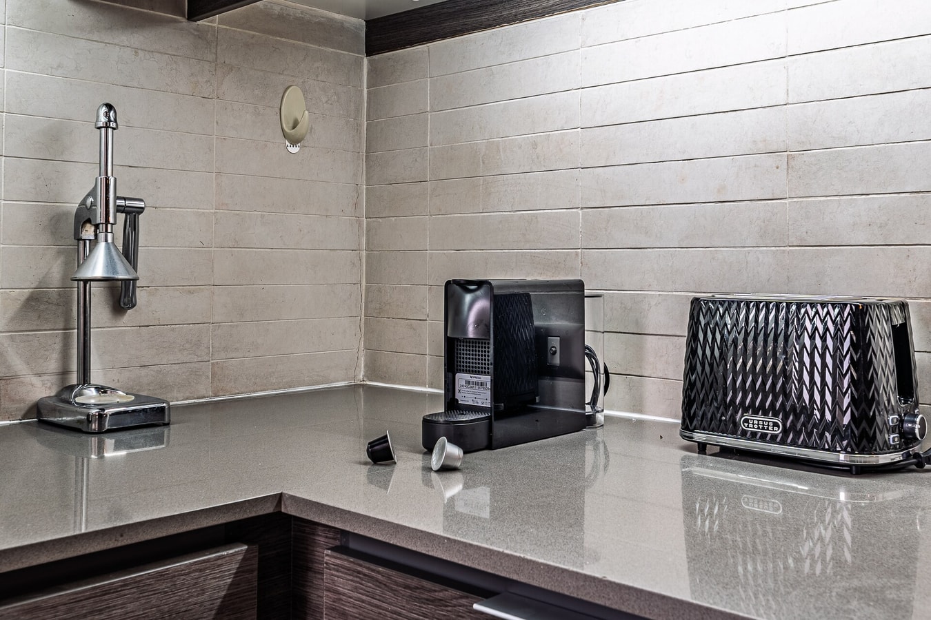 Esquina de cocina con cafetera, tostador y encimera de granito.