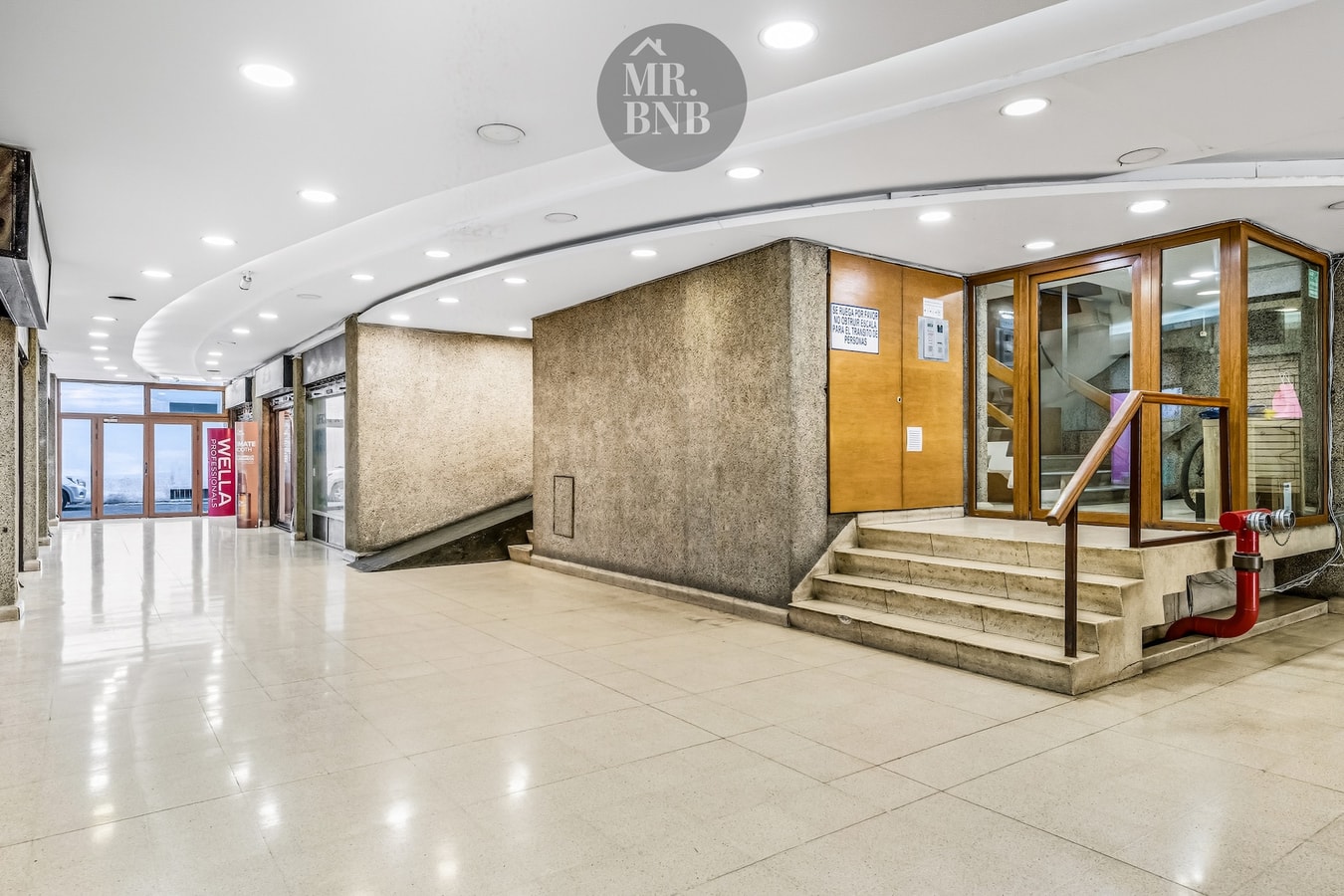 Hall de acceso del edificio con escaleras y ascensor