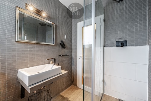 Baño de suite con ducha de vidrio y lavamanos alargado