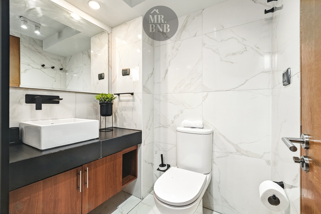 Baño con mueble vanitorio de dos lavamanos, WC y ducha con mampara de vidrio