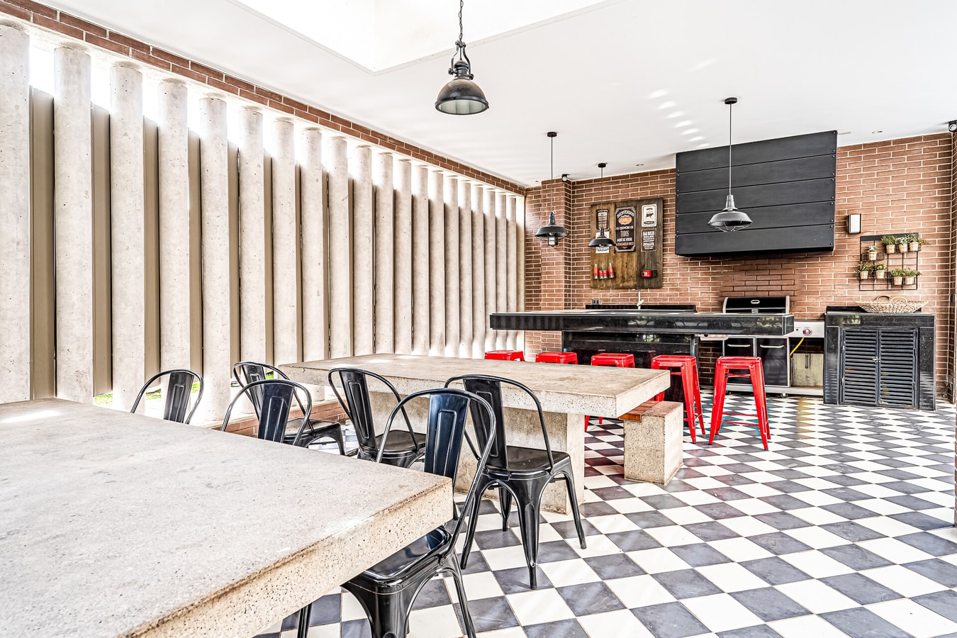 Quincho del edificio con mesas, parrilla y televisor