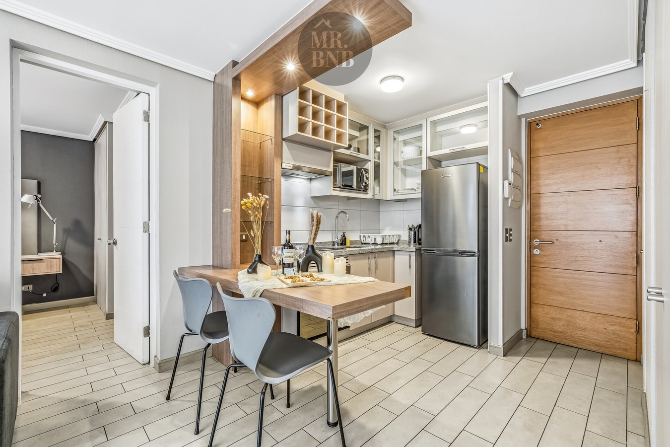 Comedor con mesa de madera, refrigerador y puerta de acceso