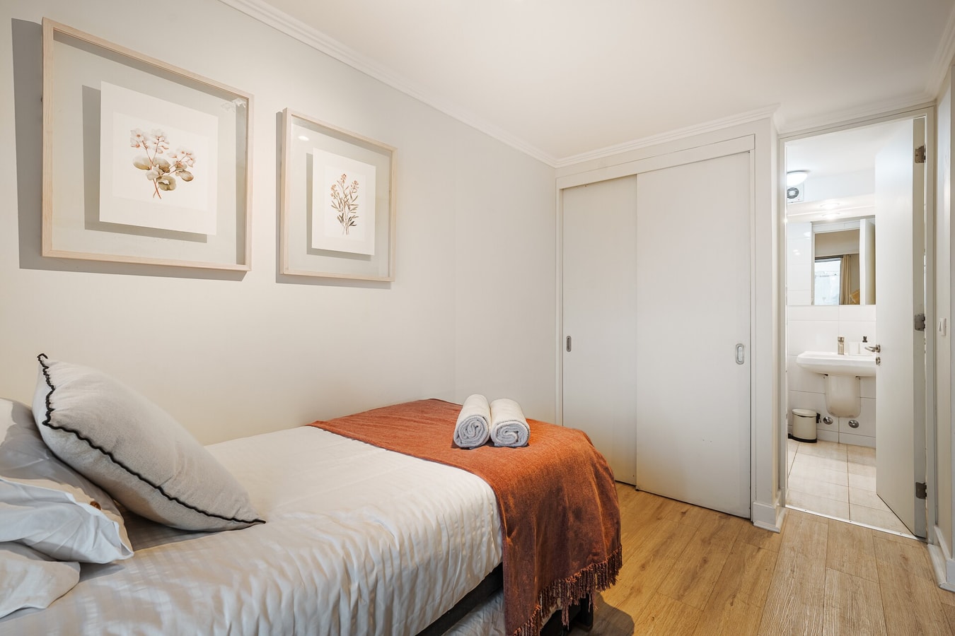 Dormitorio con cama, manta café y puertas correderas de closet