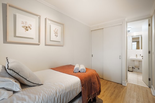 Dormitorio con cama, manta café y puertas correderas de closet