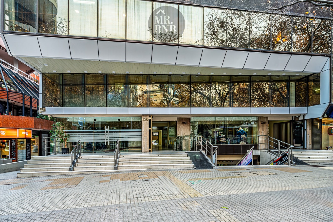 Fachada del edificio con acceso comercial y escalinata