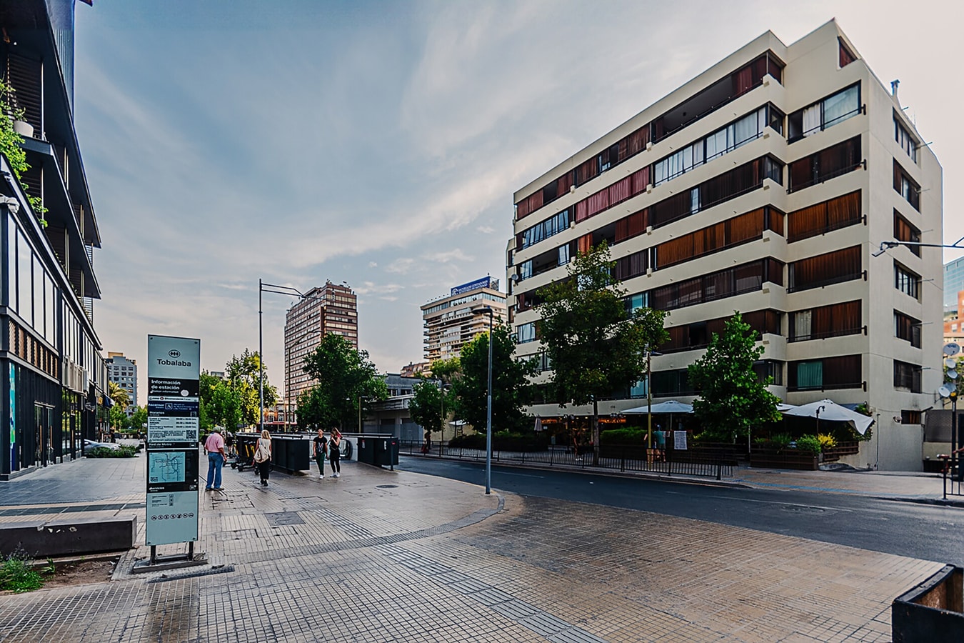Fachada del edificio con plaza y arbolado frente al acceso.