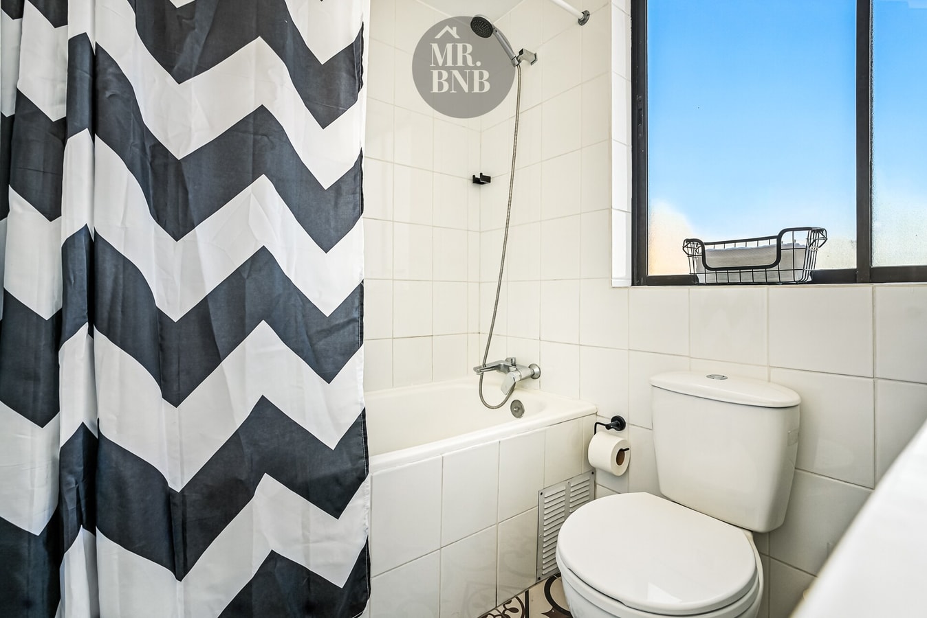 Baño con tina, cortina a rayas, ducha e inodoro