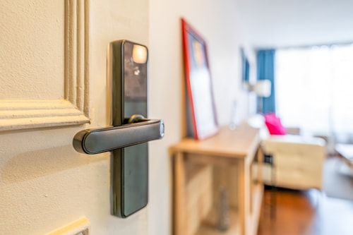 Detalle de cerradura electrónica de la puerta de entrada, con living de fondo