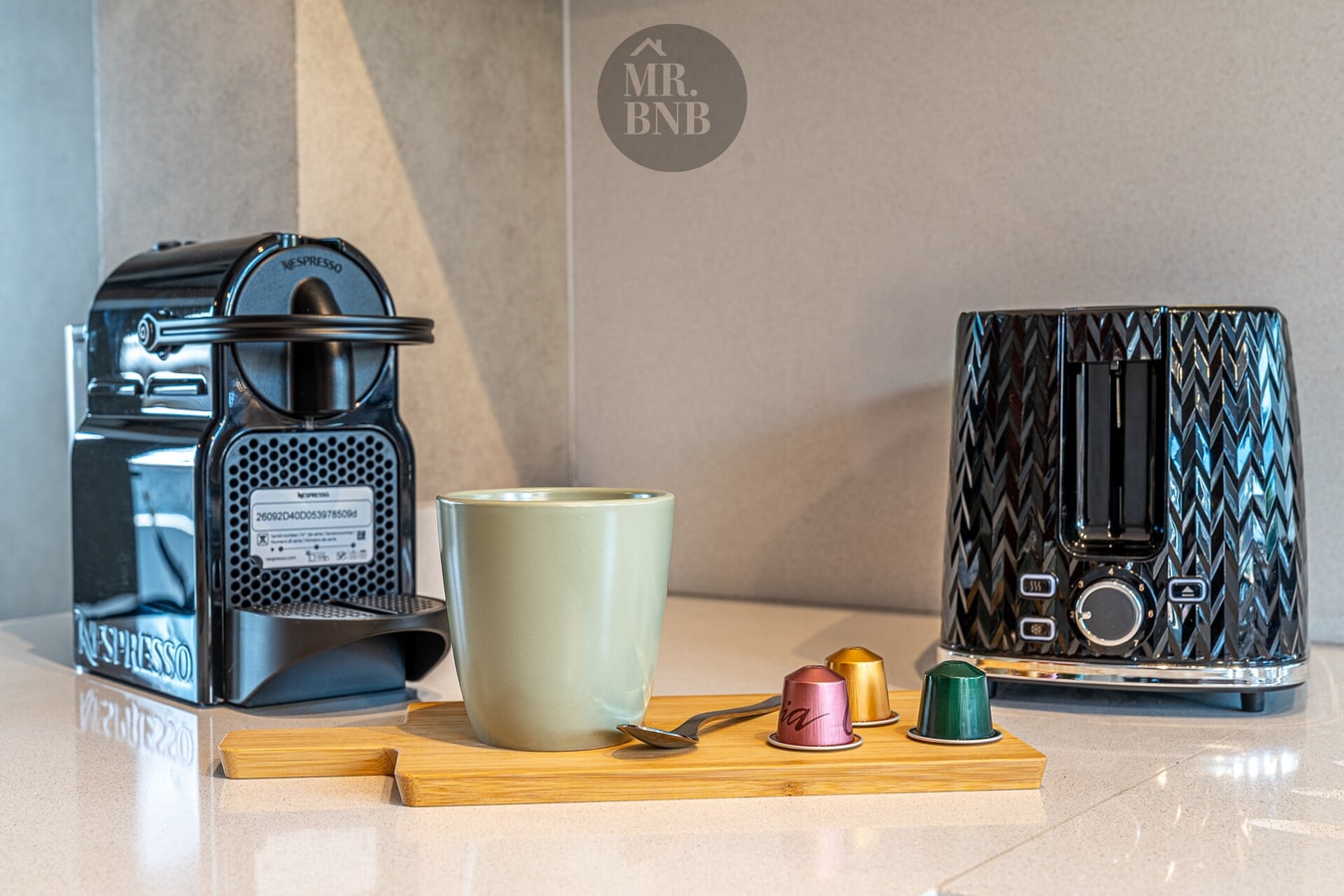 Detalle de cafetera Nespresso, tostador y taza sobre mesón