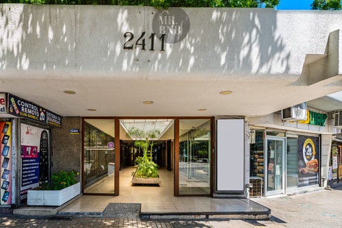 Fachada del edificio con acceso, número 2411 y locales comerciales