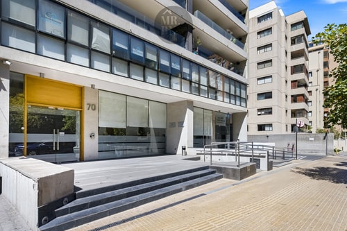 Fachada de acceso del edificio, con entrada principal y escalinata hacia la calle.