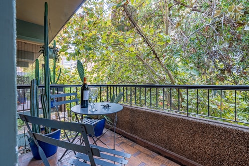 Terraza privada de suite con mesa, sillas y vista a follaje de árboles