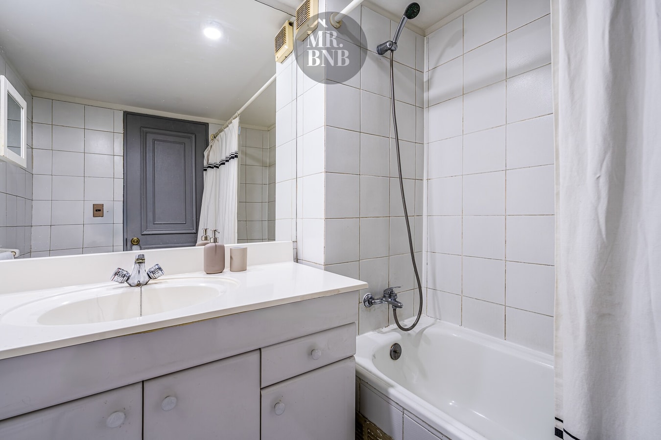 Baño con tina, ducha telefono y lavamanos gris