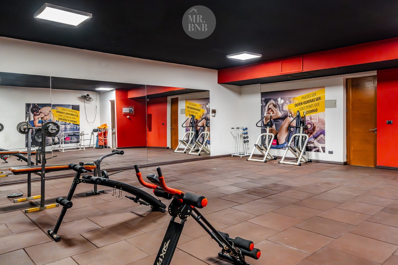 Gimnasio del edificio con máquinas de musculación y bicicleta estática