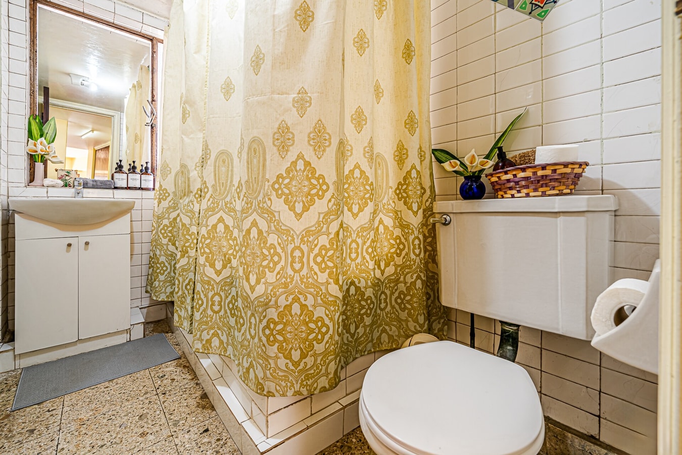 Baño con cortina estampada, tina, ducha, WC y lavamanos