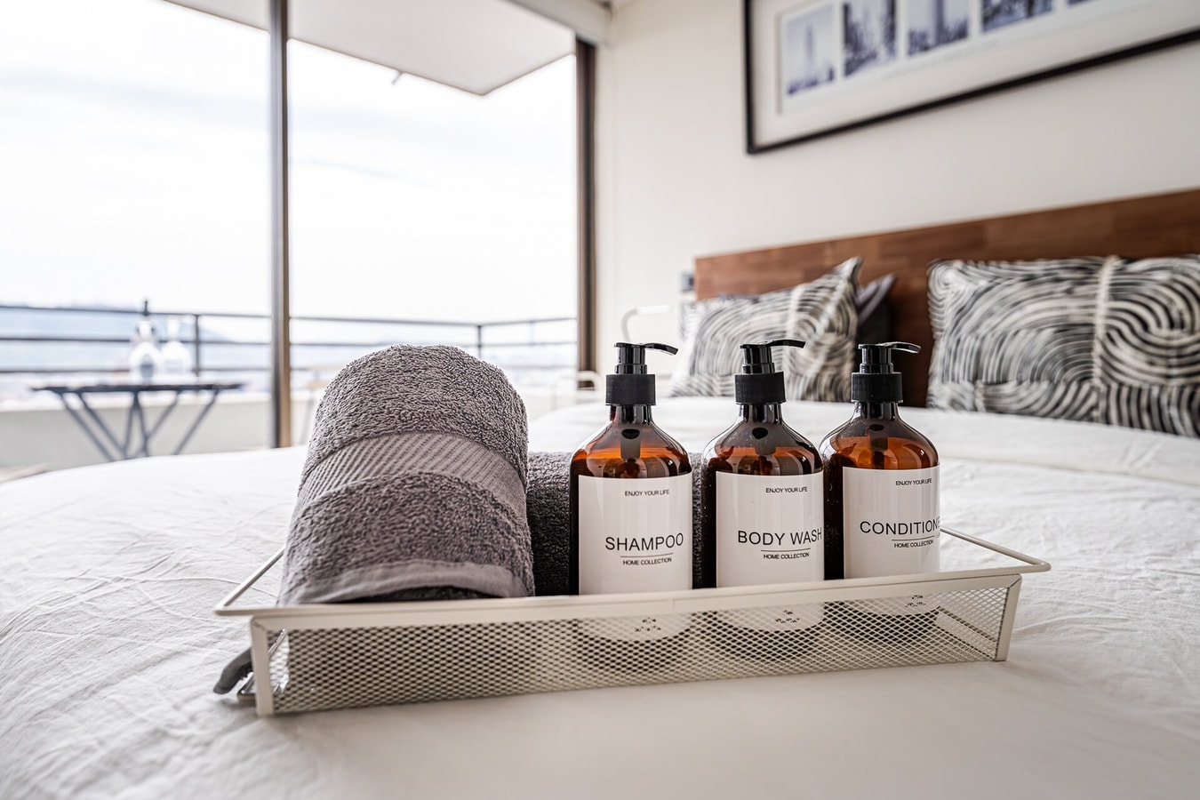 Detalle de cama con amenities de baño y toalla enrollada