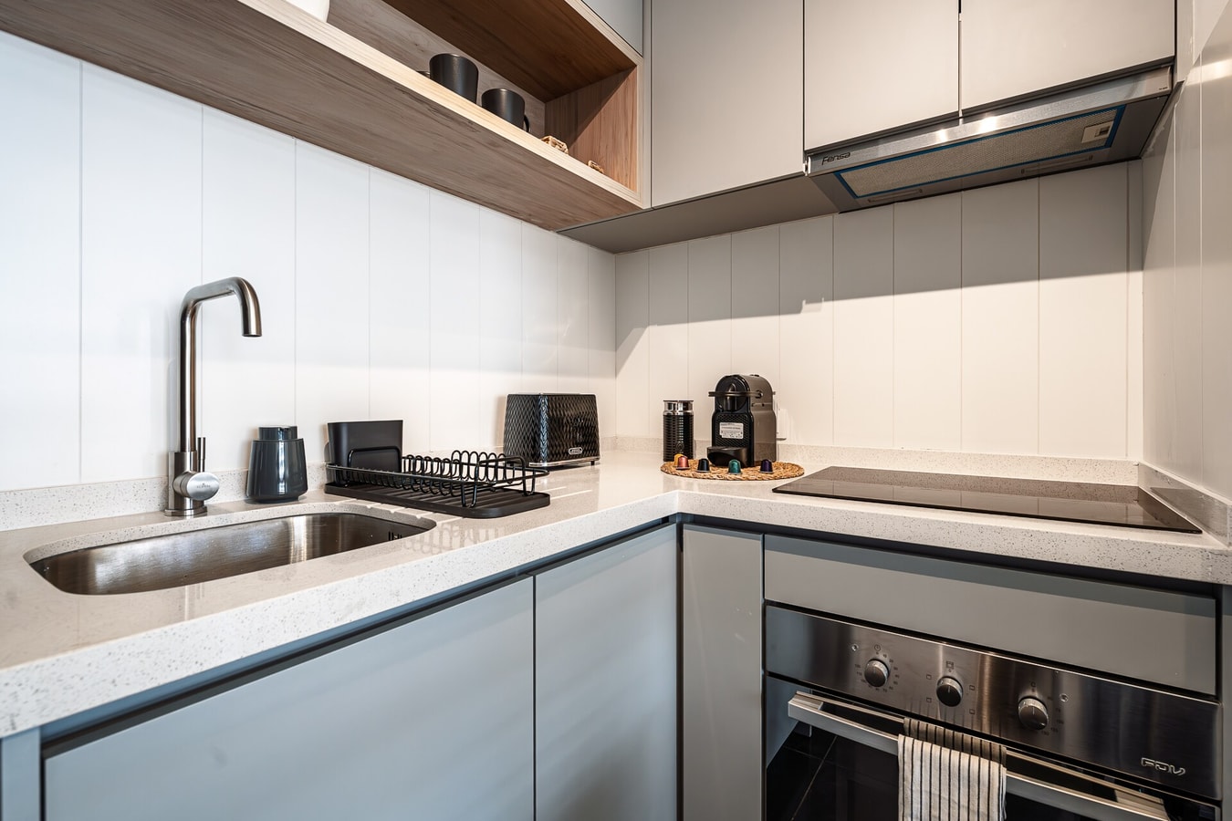 Cocina con lavaplatos, cooktop y campana