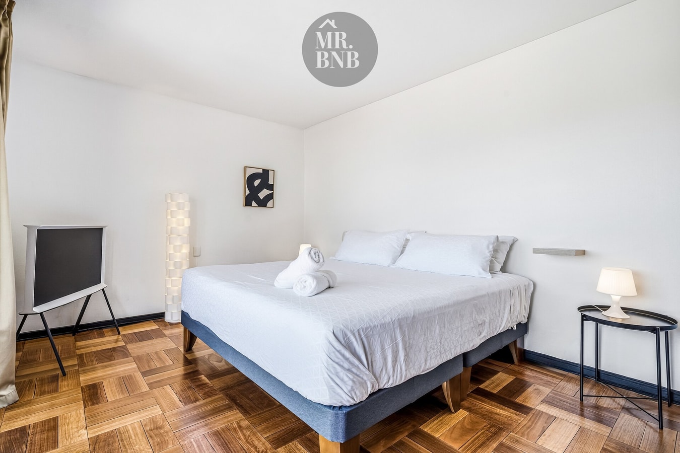 Dormitorio con cama, lámparas y cuadro decorativo