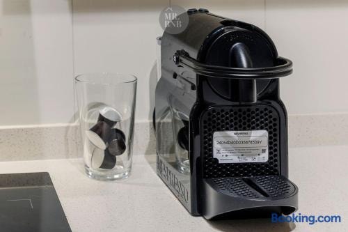 Detalle de cafetera y vaso de vidrio sobre la encimera de la cocina.
