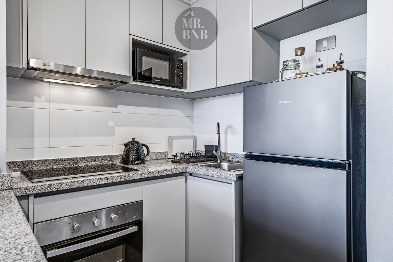 Cocina equipada con encimera, cocina a gas, horno y refrigerador