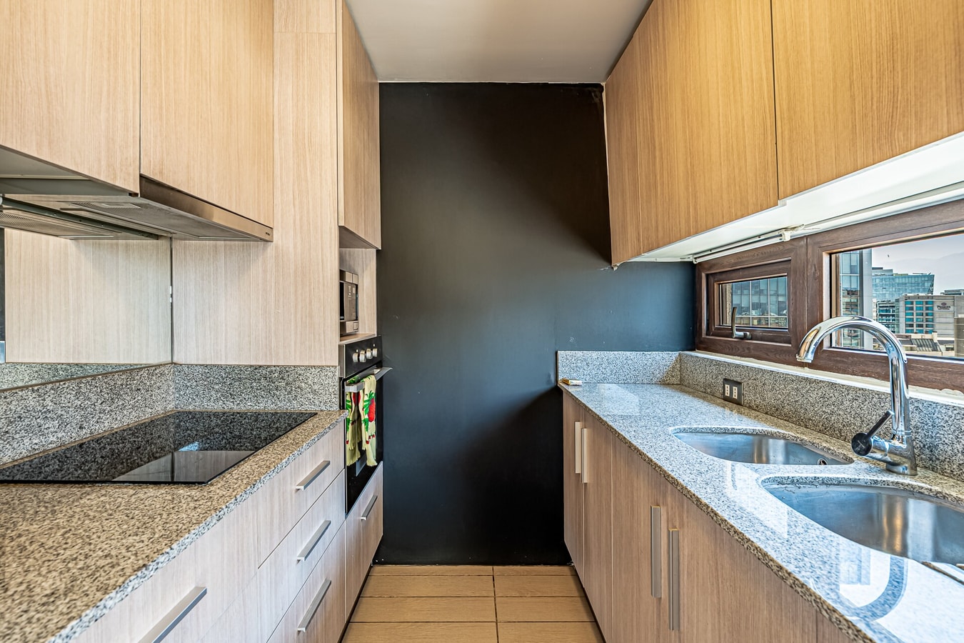 Cocina en L con muebles de madera, campana y lavaplatos doble