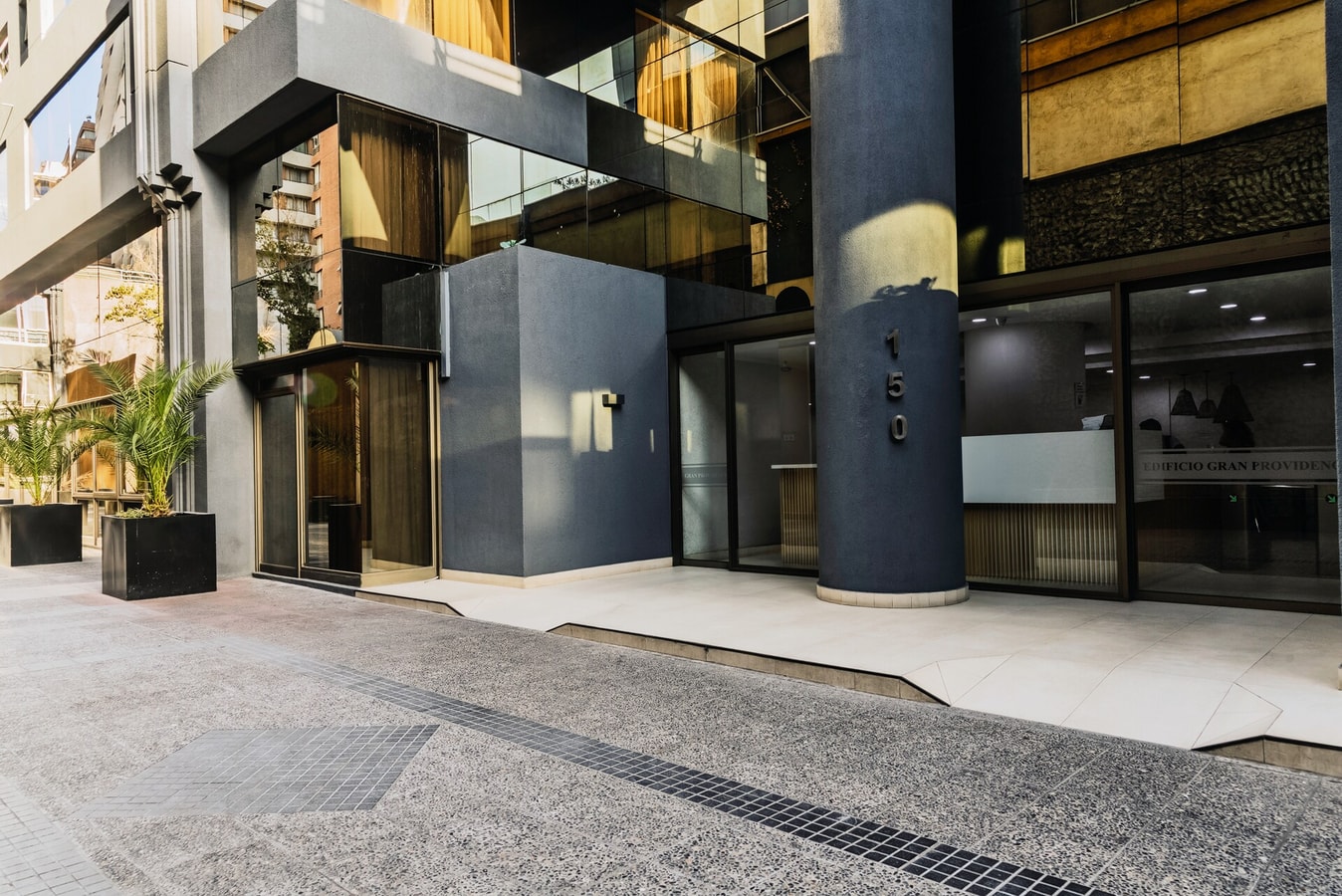 Fachada de acceso del edificio con letrero de hotel y entrada de vidrio