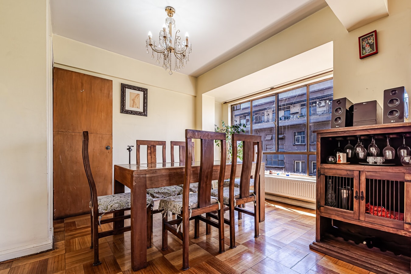 Comedor con mesa de madera para seis sillas, aparador con copas y lámpara araña