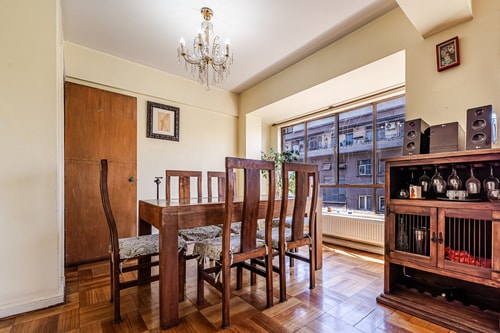 Comedor con mesa de madera para seis sillas, aparador con copas y lámpara araña