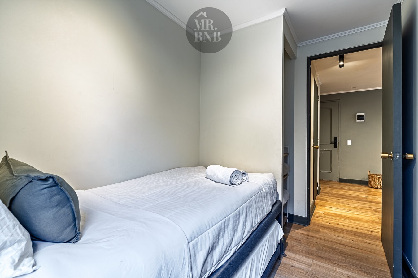 Dormitorio con cama, veladores y pasillo hacia otras habitaciones