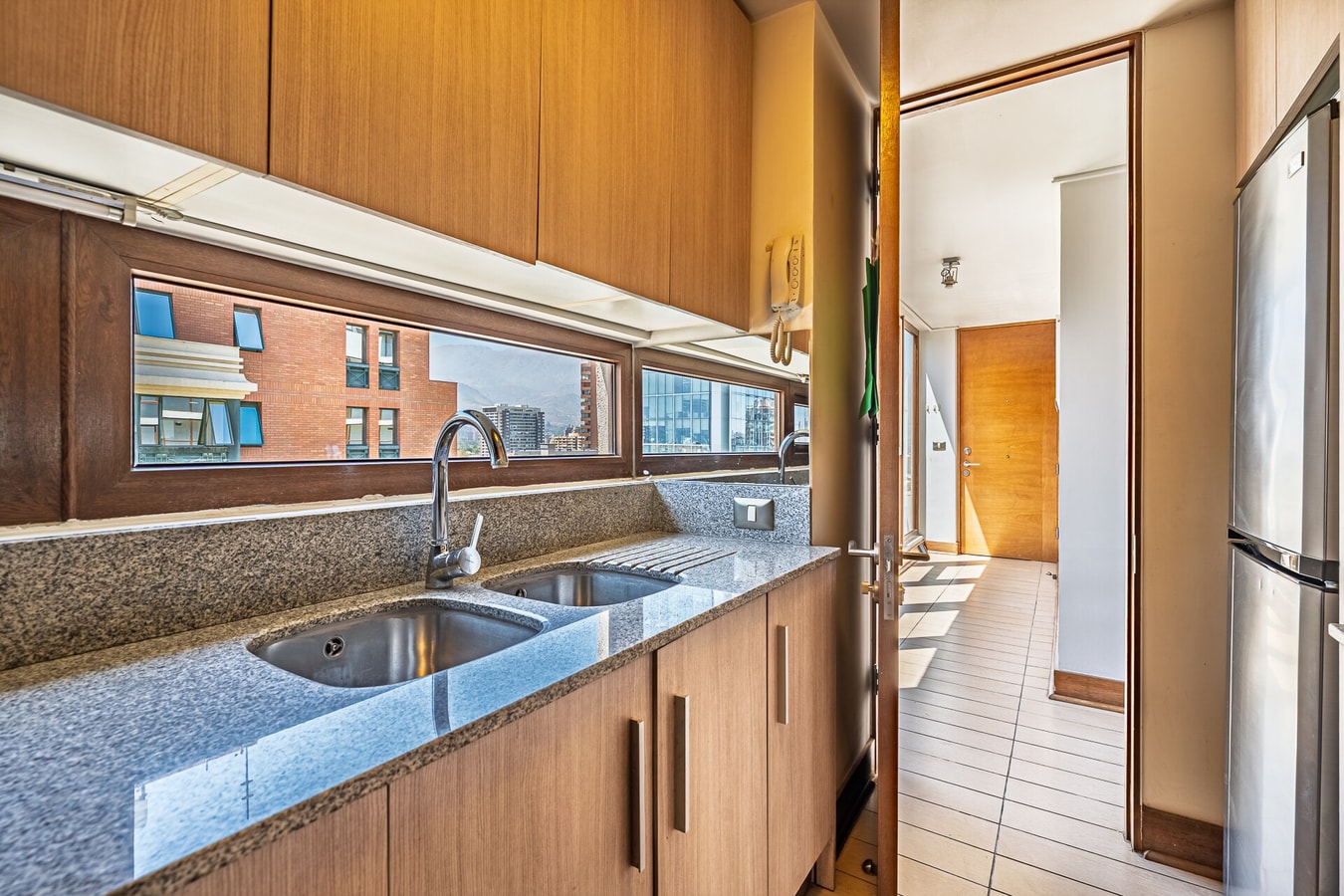 Cocina con encimera de granito, lavaplatos doble y ventana