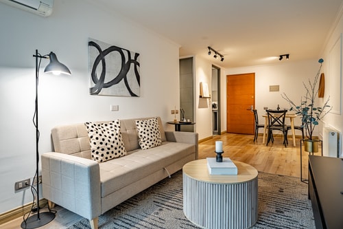 Living con sofá, mesa de centro y comedor al fondo del pasillo