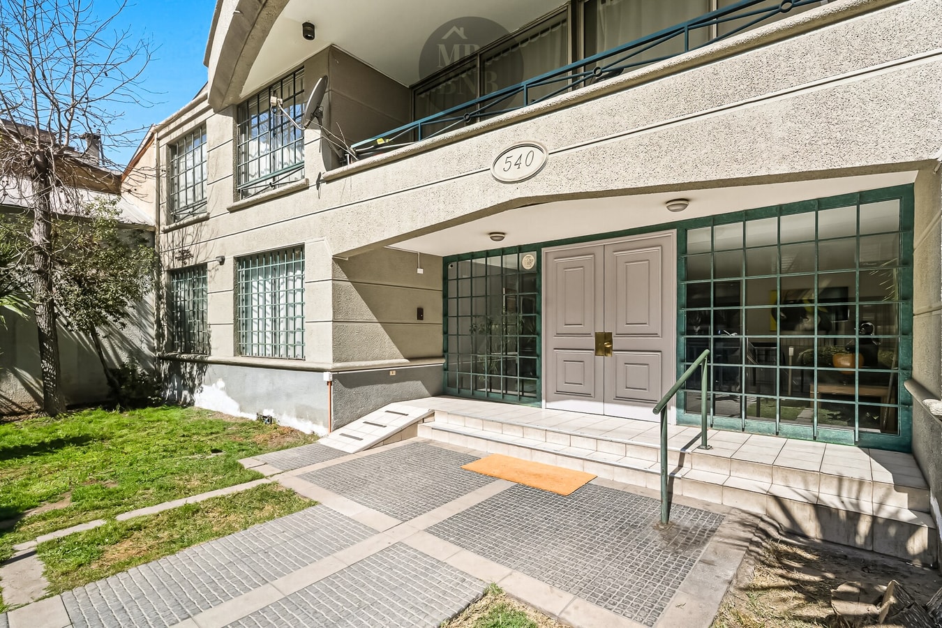 Fachada del edificio con jardín, acceso peatonal y numeración 540