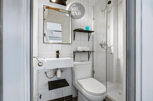 Baño de suite con ducha de vidrio, lavamanos y toallas