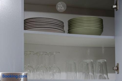Repisa de cocina con platos, copas y vasos ordenados.