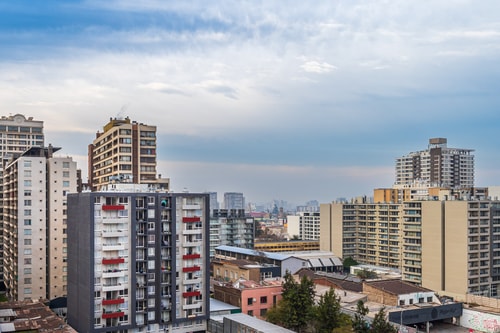 Vista panorámica de la ciudad y edificios circundantes desde una ventana en altura.