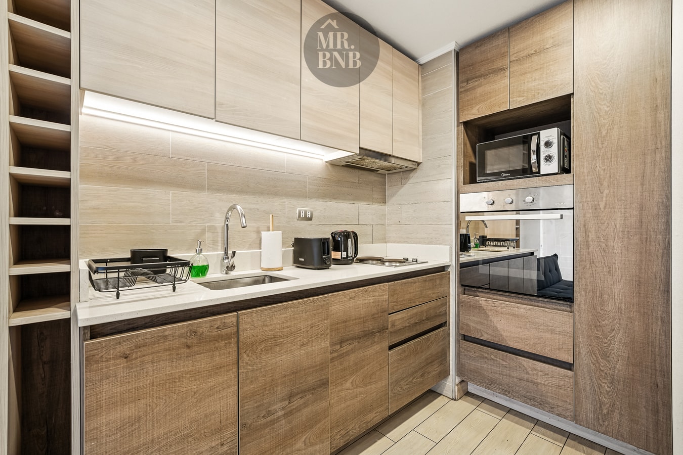 Cocina en L de madera con cocina a gas, horno, microondas y extractor.