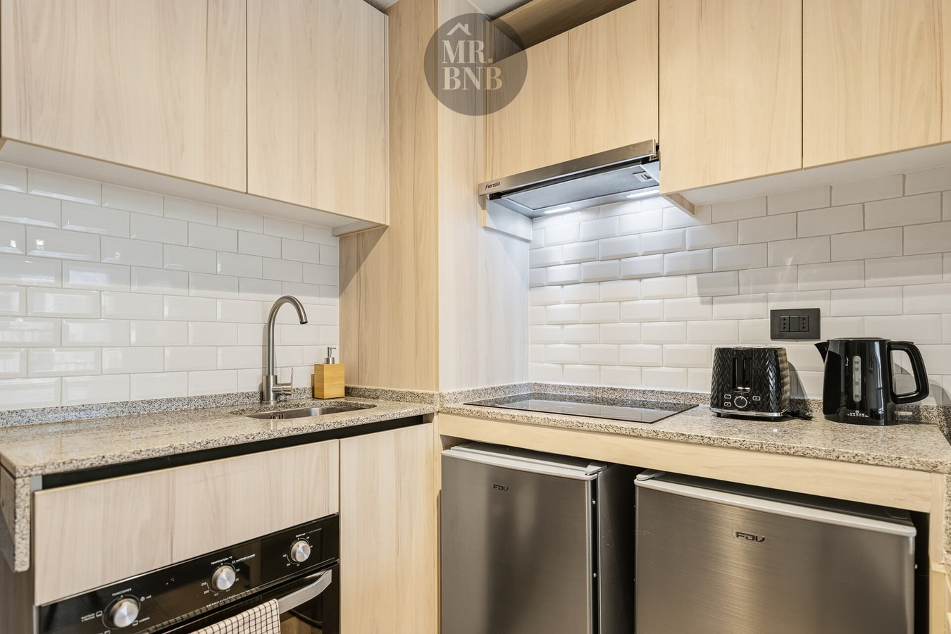 Cocina equipada con encimera de granito, horno, hervidor, tostador y refrigerador