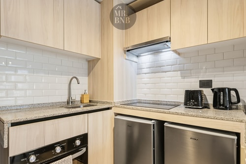 Cocina equipada con encimera de granito, horno, hervidor, tostador y refrigerador
