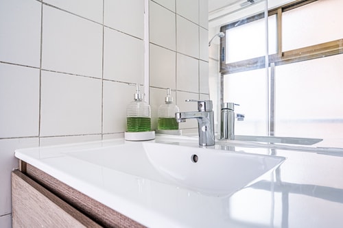 Detalle del lavamanos del baño, con grifería y dispensadores