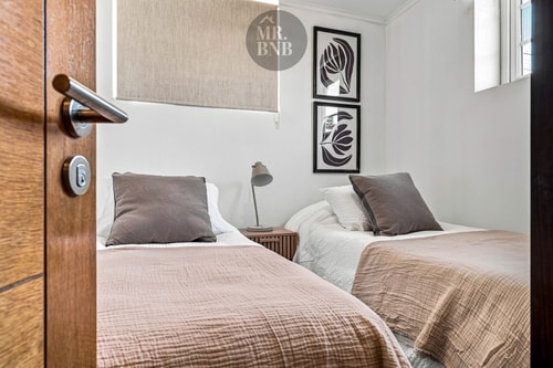Dormitorio con dos camas individuales y puerta de madera
