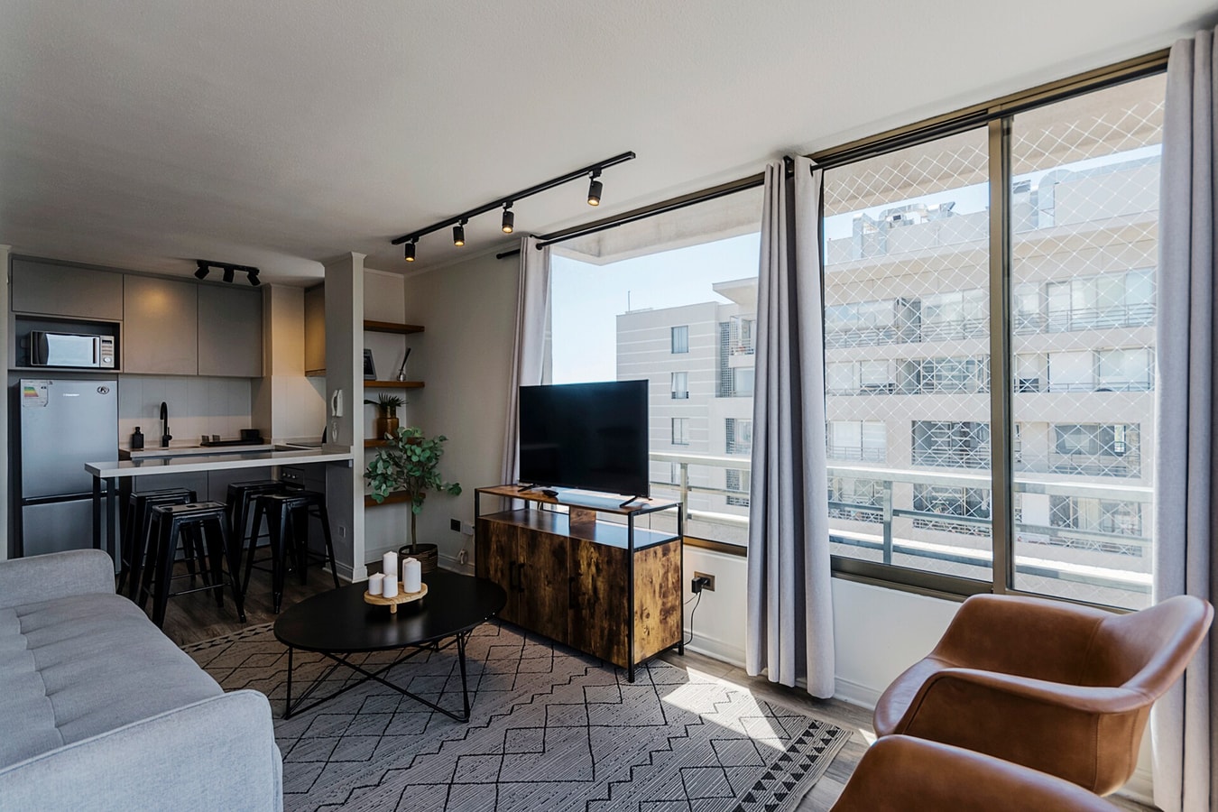 Living comedor con barra, taburetes, TV, ventanal y carro auxiliar