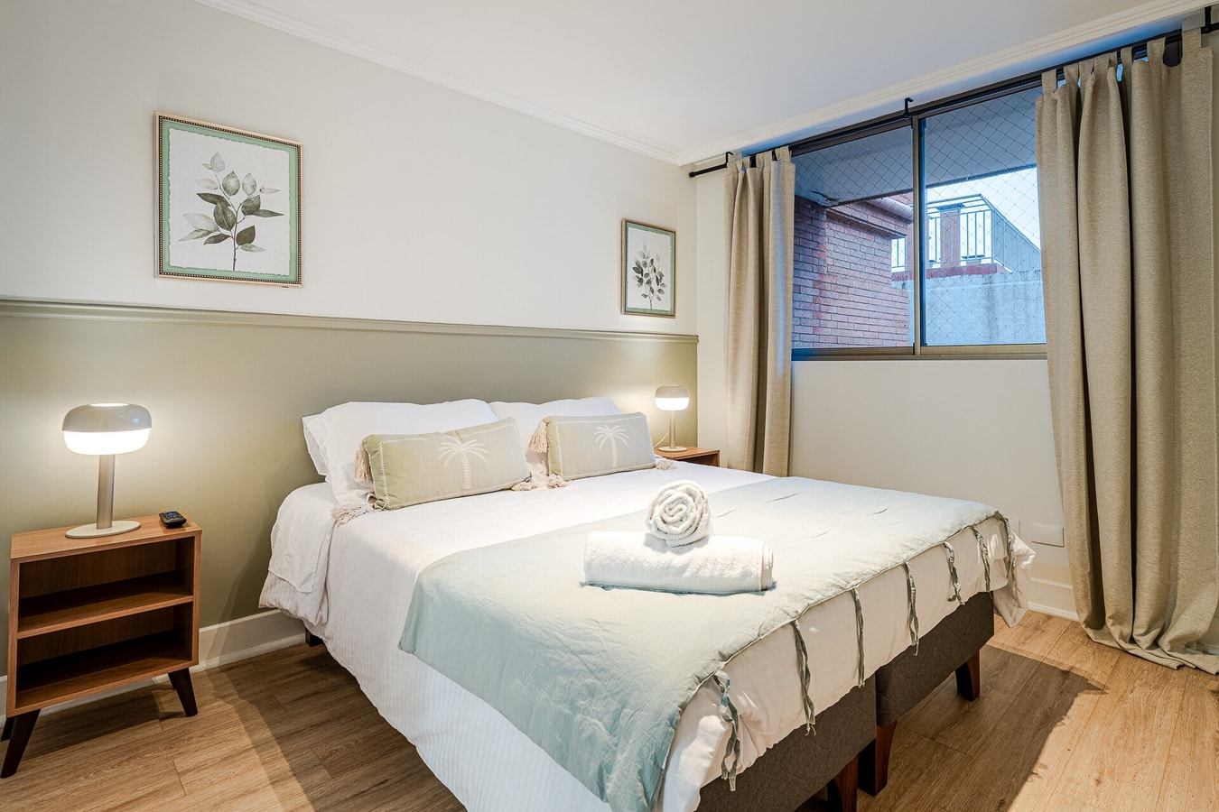 Dormitorio con cama, veladores con lámparas y ventana con cortinas