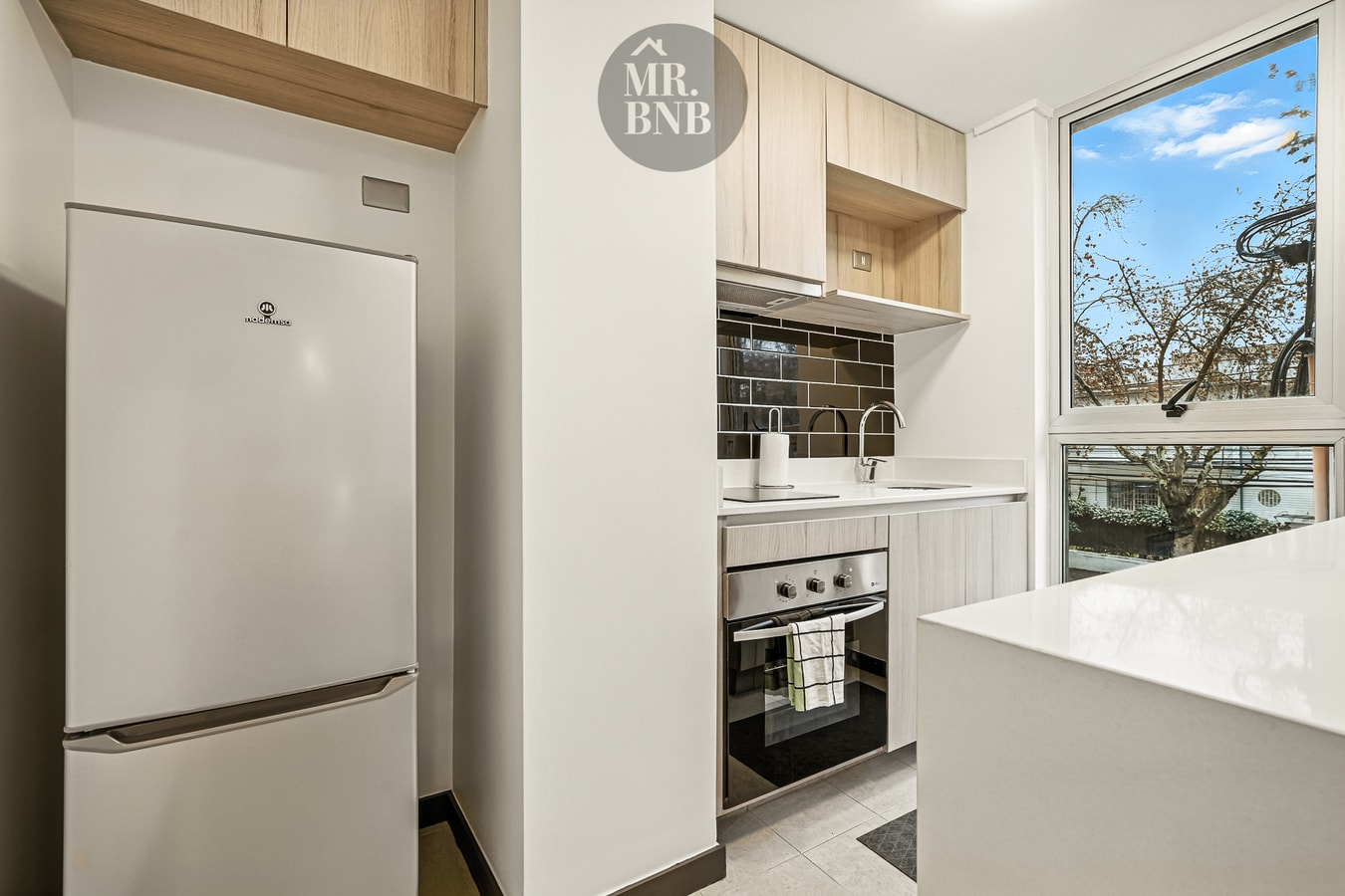 Cocina con refrigerador, horno, cocina y muebles superiores de madera