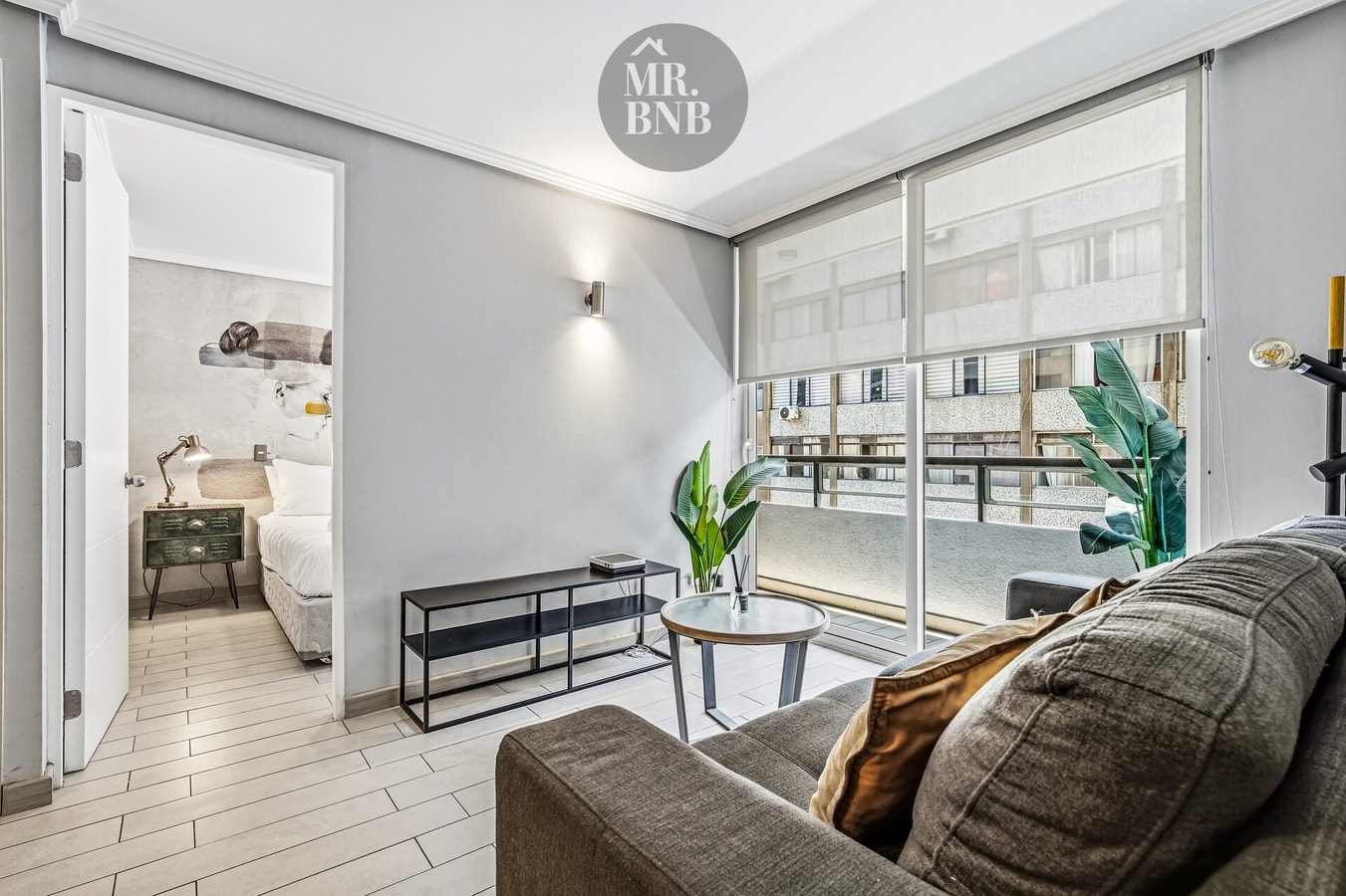 Living con sofá, mesa auxiliar y vista hacia el dormitorio