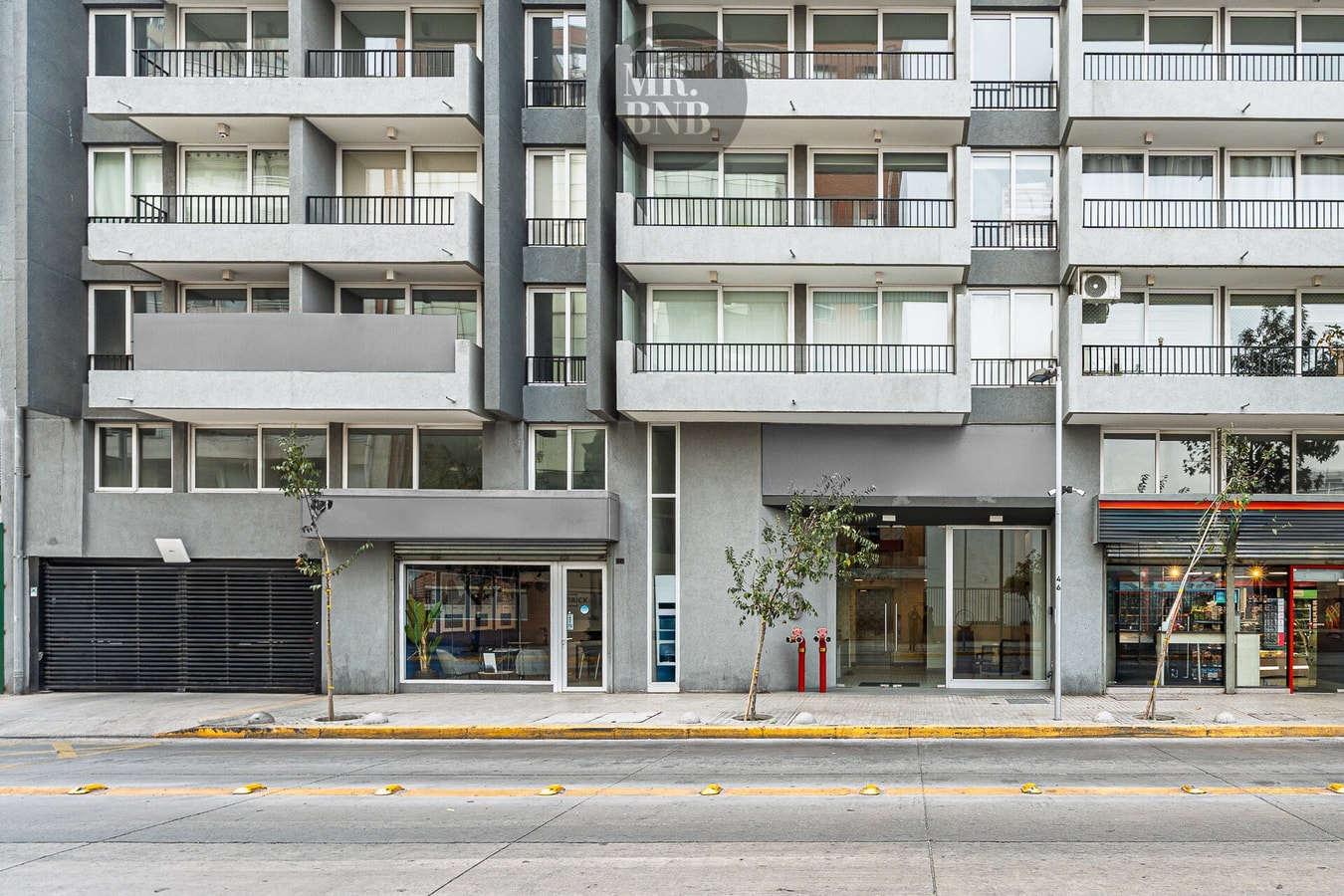 Fachada del edificio sobre la avenida, con locales comerciales en el primer piso.